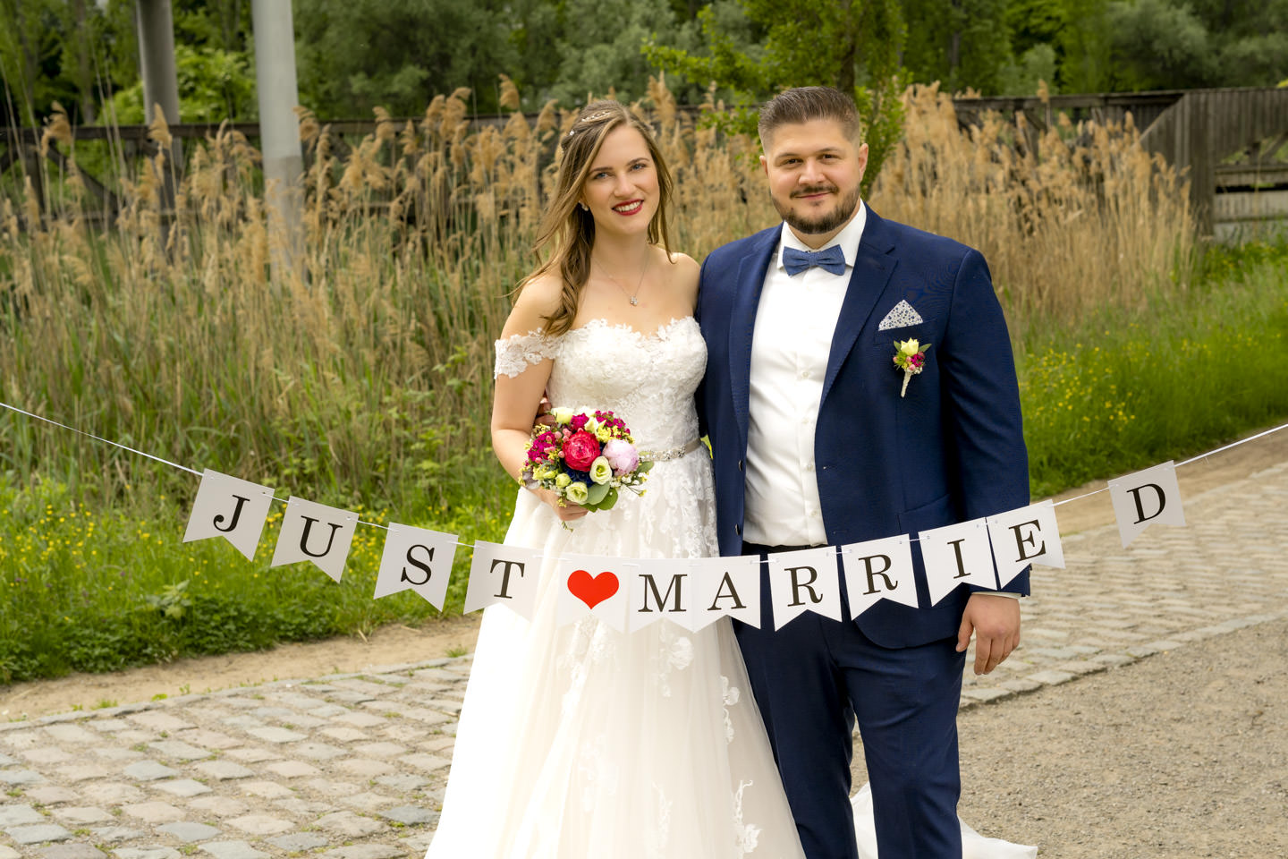 Brautpaar mit Just Married Banner im Seepark Freiburg, fotografiert von Hochzeitsfotograf Gregor Marstaller.