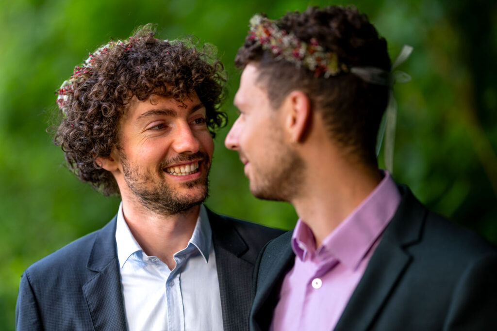 Zwei Männer beim emotionalen Verlobungsshooting am Waldsee Freiburg, inniger Moment in eleganten Anzügen.