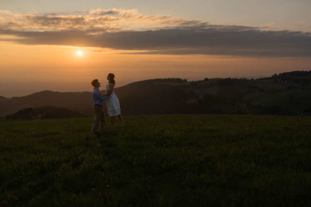 Paar bei Sonnenuntergang auf dem Schauinsland mit Blick über den Schwarzwald bei Freiburg.