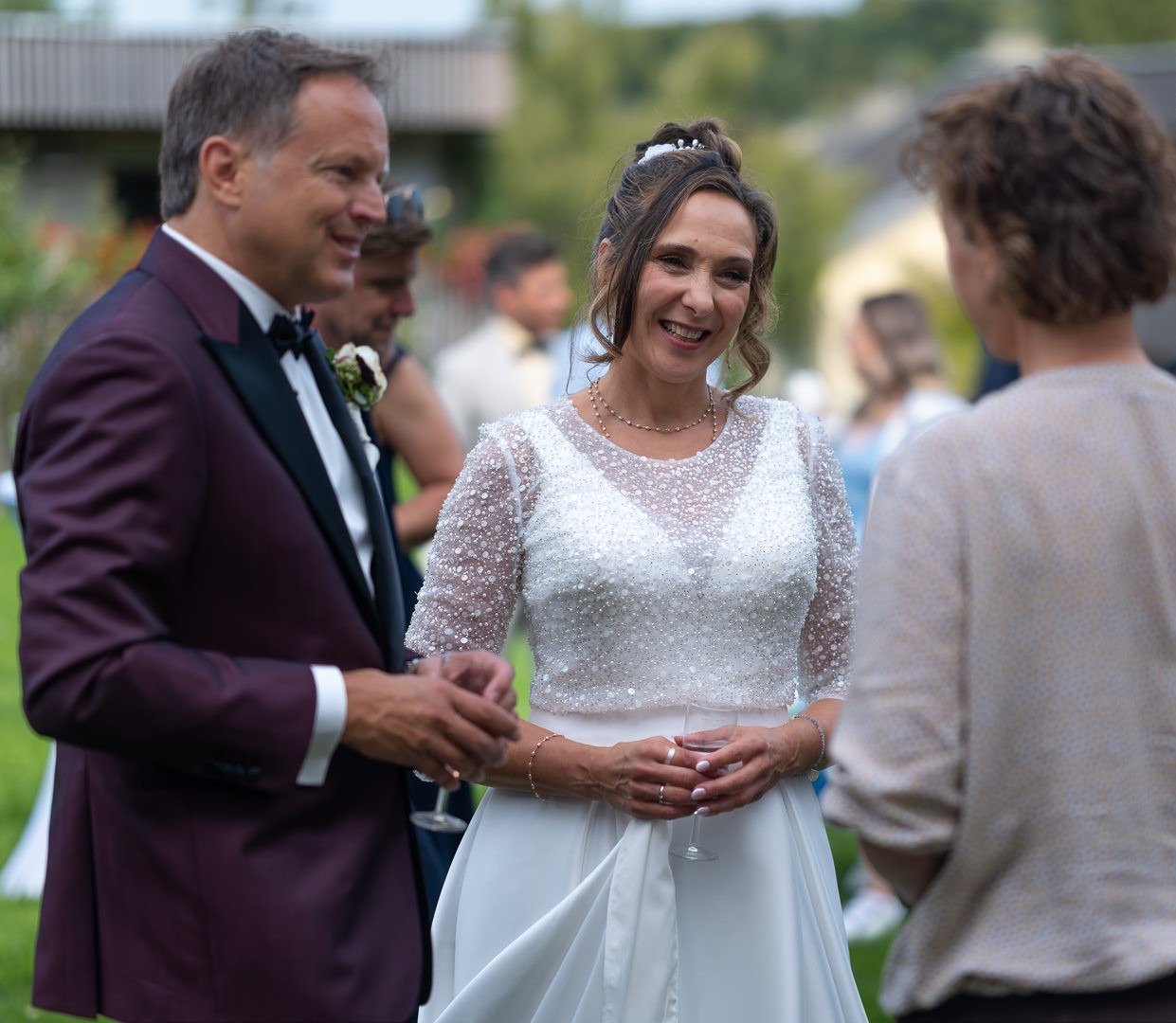 Braut im Spitzenkleid mit Gästen bei eleganter Outdoor-Hochzeit in Meersburg am Bodensee.