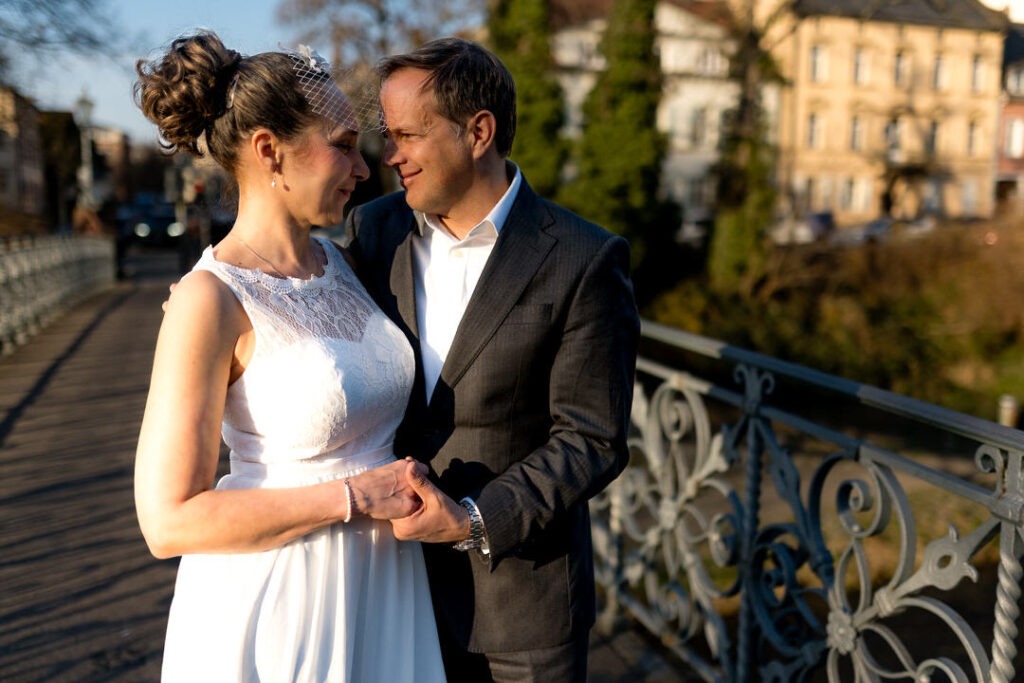 Brautpaar beim Engagementshooting auf Brücke in Freiburg während der Golden Hour.