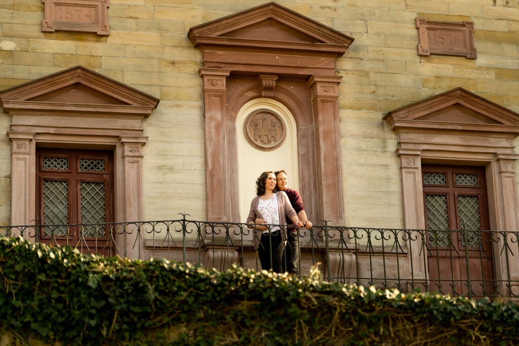 Brautpaar beim Engagementshooting vor historischer Fassade am Schlossberg Freiburg mit elegantem Säulenportal.
