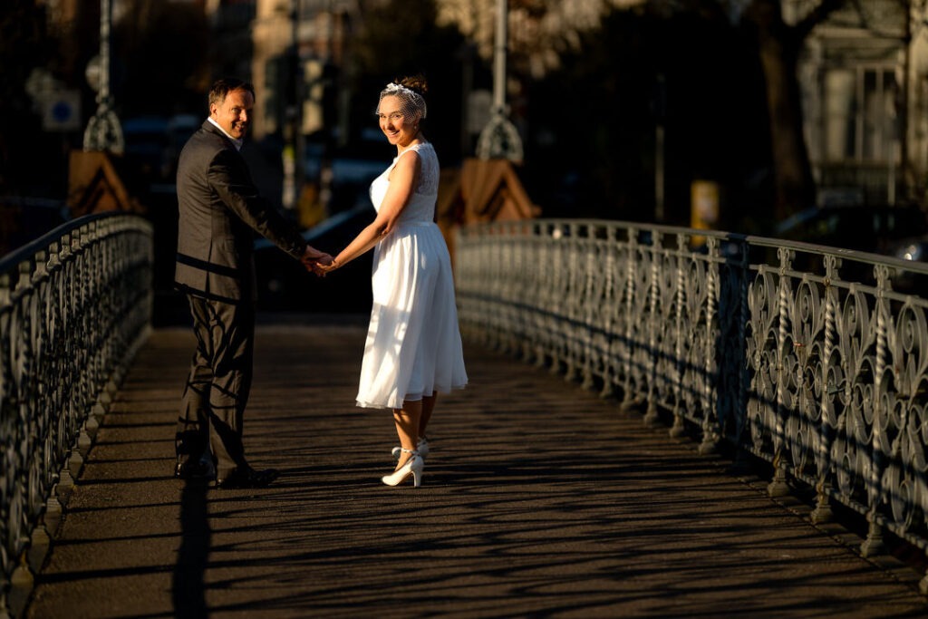 Paar beim Engagementshooting im Gegenlicht auf historischer Brücke in Freiburg im Breisgau.