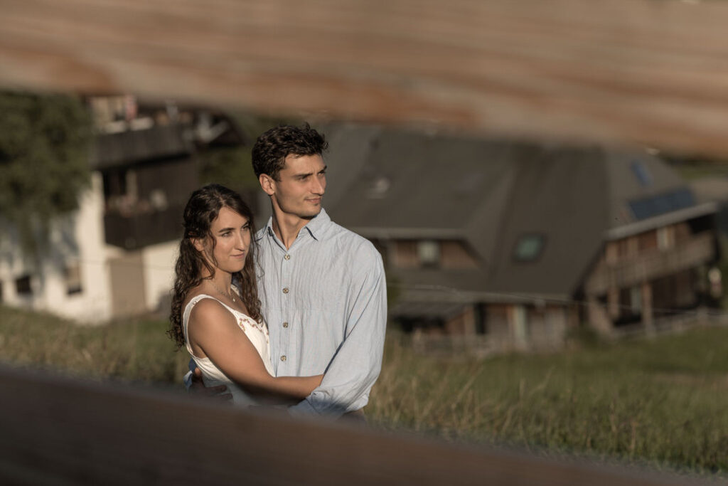 Verliebtes Paar beim Engagement-Shooting vor Schwarzwald-Kulisse mit traditionellen Häusern bei Freiburg.