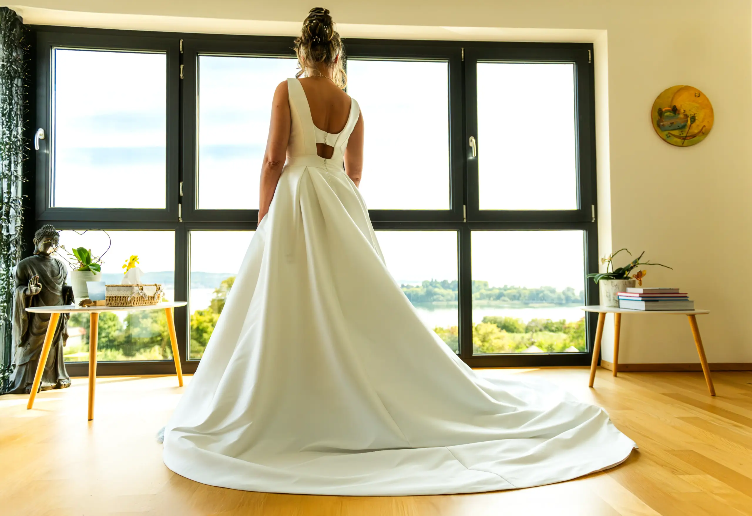 Braut an einem Panoramafenster am Bodensee