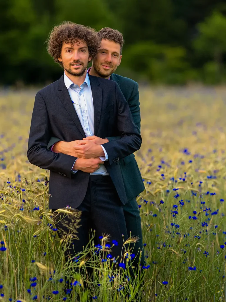 Florian und Martin umarmen sich im Kornblumenfeld, Freiburg 2025.