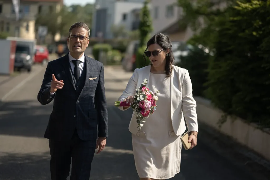 Hochzeitsreportage Steffi und Michael laufen gemeinsam durch eine sonnige Straße.