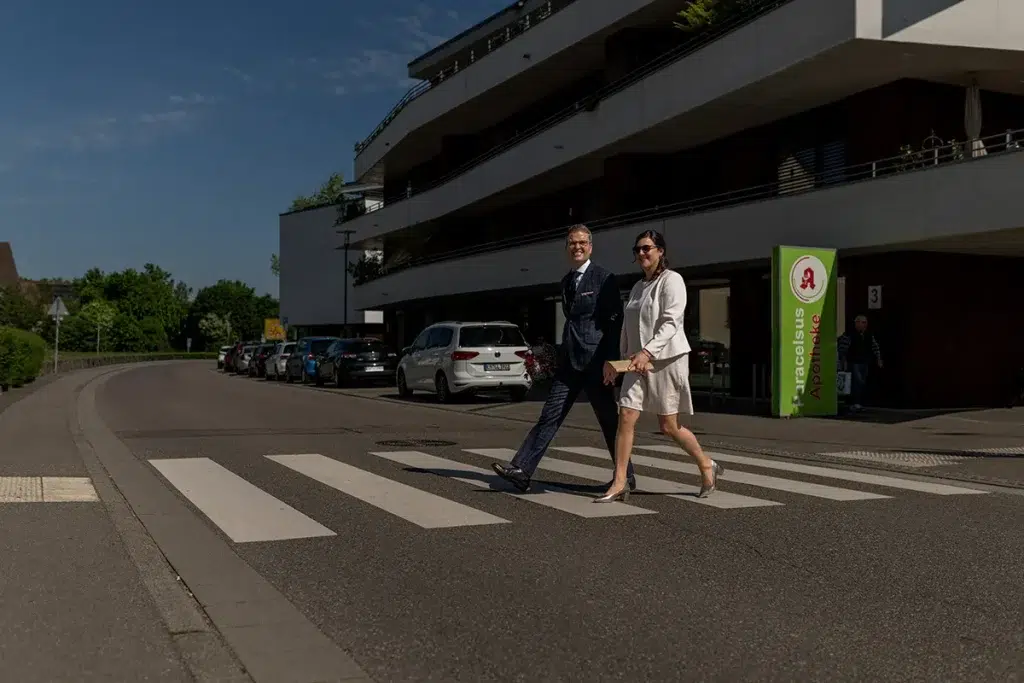 Hochzeitsreportage Steffi und Michael überqueren einen Zebrastreifen in Freiburg.
