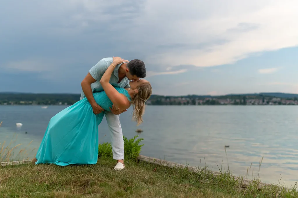 Verlobungsshooting Bodensee – Svenja und Yannik küssen sich im Dip am Seeufer.