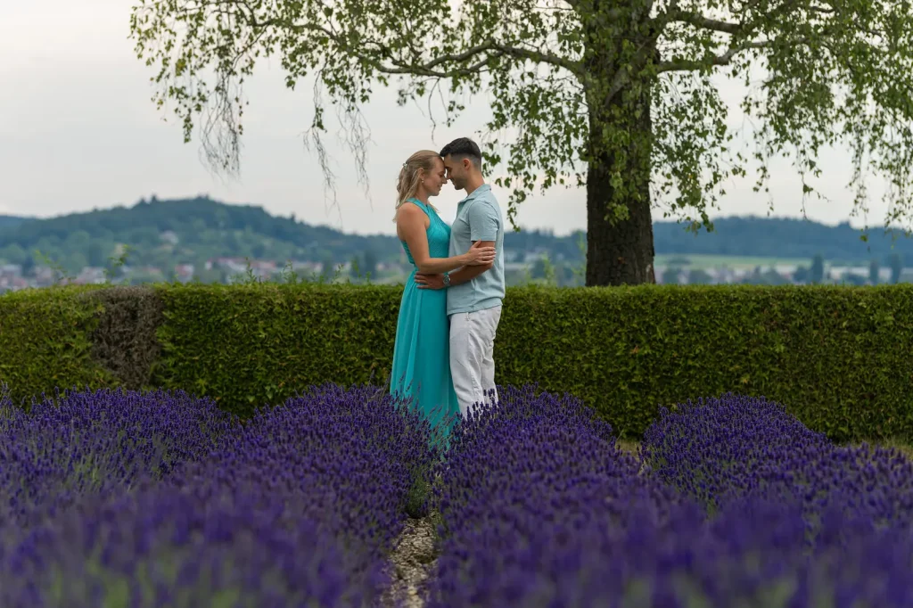 Paarfoto Svenja und Yannik im Lavendelfeld, Hecke und Birke dahinter.